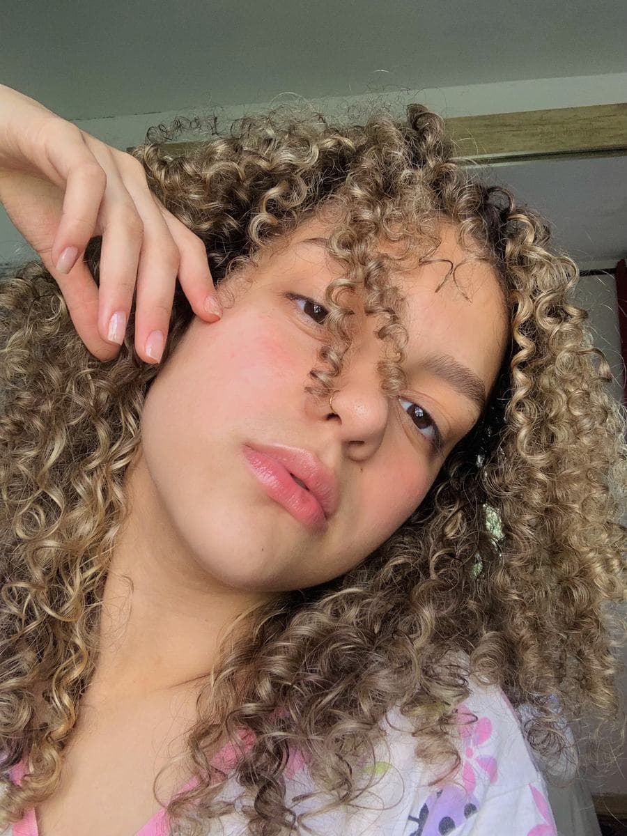 Melissa Oliveira em retrato natural e espontâneo, luz do dia, cabelos cacheados — estilo UGC
